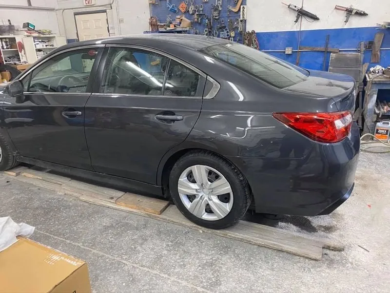 Completed sedan repair with new door, quarter panel, and rear bumper