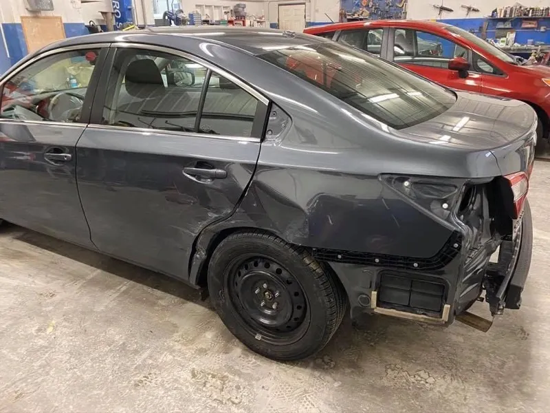 Sedan with rear quarter panel and bumper damage before repair